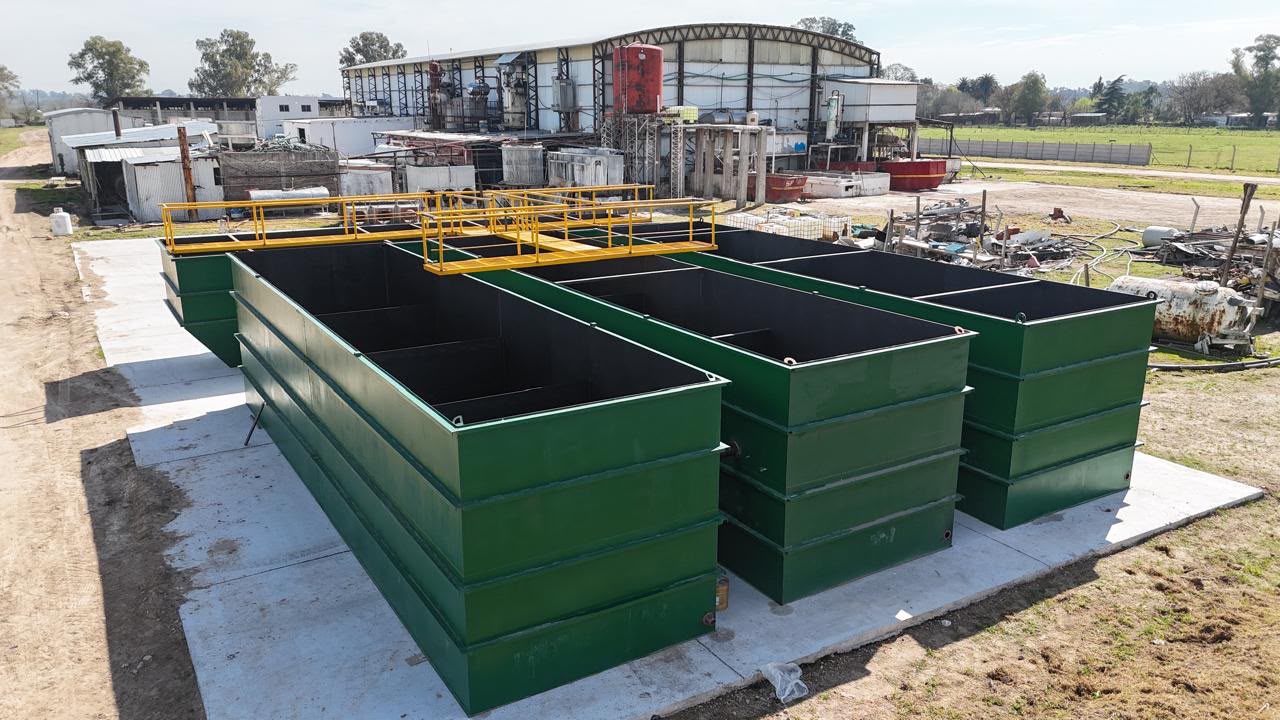 Planta de tratamiento de efluentes con tanques verdes y pasarelas amarillas fabricada por CM